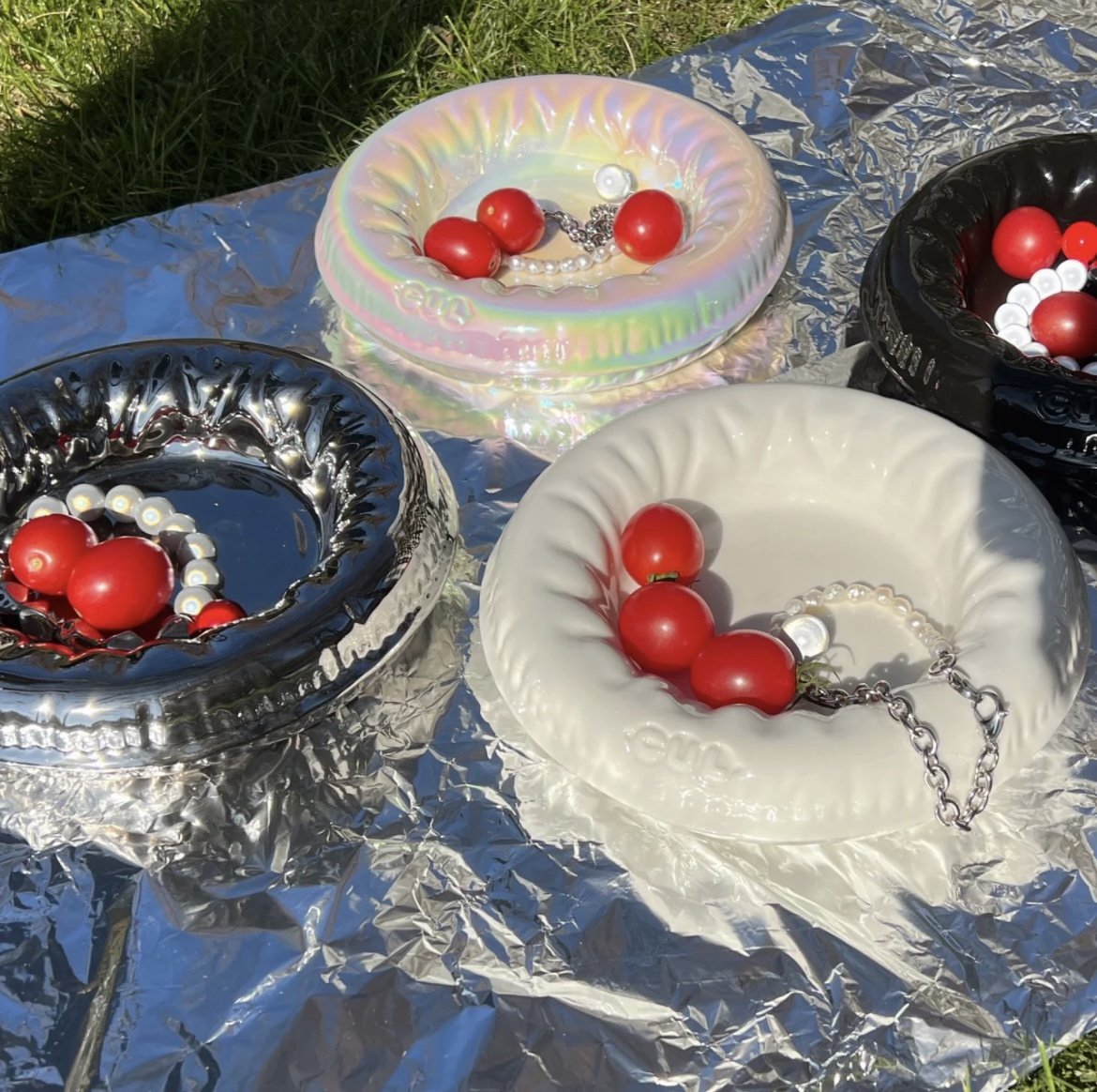 Modern Pet Bowl Collection in Assorted Colors – Sleek, reflective designs perfect for stylish pet dining. Features silver, iridescent, black, and cream bowls with vibrant red cherry decor, enhancing any pet-friendly home decor aesthetic.