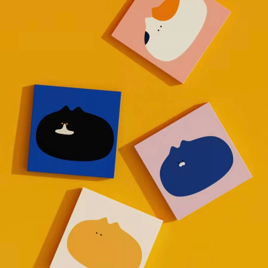 Maogeju cat wall art — four minimalist cat silhouettes on colorful square canvases against a yellow wall; playful home décor.