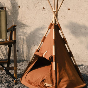 Boho Chic Pet Tent set up outdoors with its brown fabric and wooden poles, showing its simple and chic design that enhances any outdoor or indoor living space.