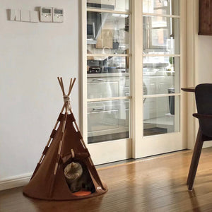 Modern home interior with a small cat relaxing inside the Boho Chic Pet Tent, blending perfectly into the minimalist décor with its brown fabric and sleek wooden structure.