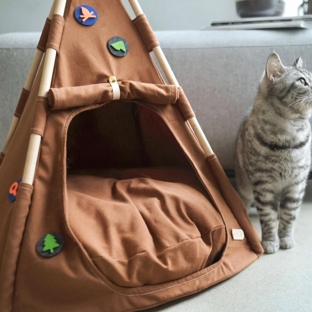 Boho Chic Pet Tent featuring decorative felt details on its exterior, designed with a brown fabric and sturdy wooden poles, creating a cozy space for pets in stylish homes.