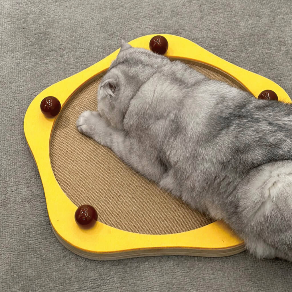 Cat laying on yellow Sisal Cat Scratcher Panel with brown ceramic decorative balls.