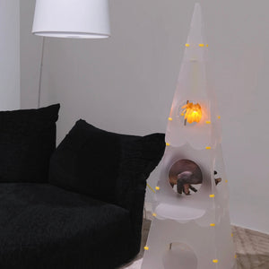 Lighthouse Cat Tower placed next to a couch, providing a stylish space for a cat to climb and relax, with the pinecone light glowing.