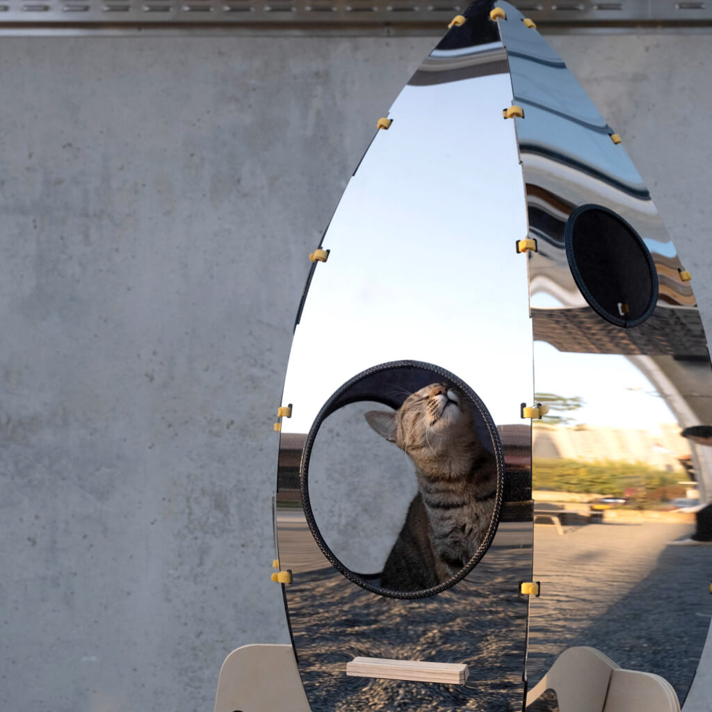 Close-up of the stainless steel exterior of the Rocket Cat Tower reflecting its surroundings.