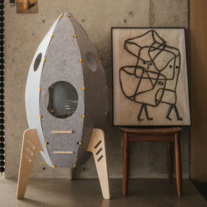 Rocket Cat Tower with modern minimalist design, placed next to an abstract art piece.