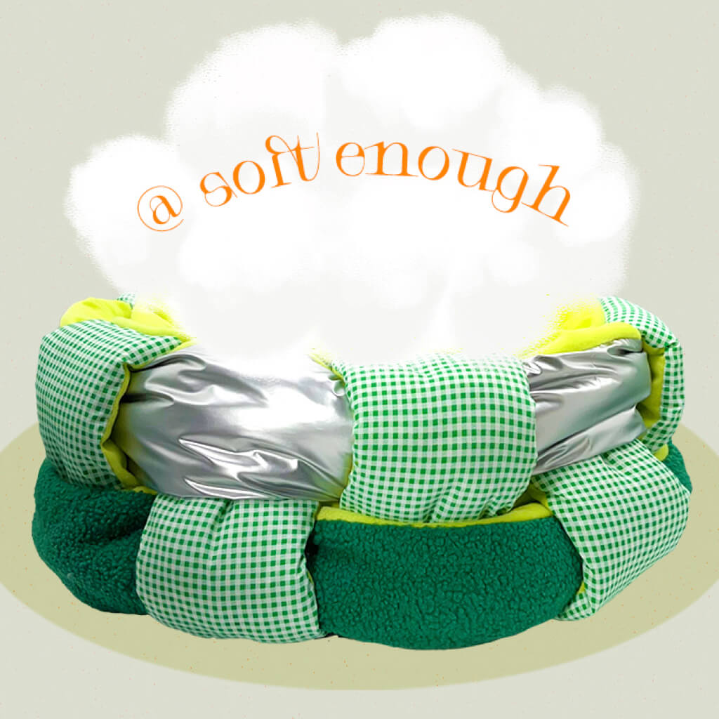 The woven-style fleece cat bed with an added graphic element of soft clouds and the text ‘soft enough,’ emphasizing the plush, cozy nature of the bed. The bright lime-green cushion contrasts with the green checkered and shiny silver accents.