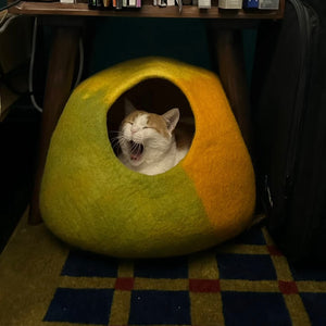 Cat yawning from Amalfi Lemon felt cat cave placed under table; cozy enclosed cat house for restful sleep.