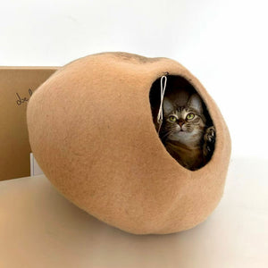 Side view: cat inside Beige Mochi wool felt cat cave — hand-felted, cozy enclosed cat bed.