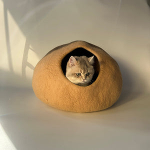 Cat lounging on Beige Mochi wool felt cat cave — durable shape-holding felt, minimalist hideaway.