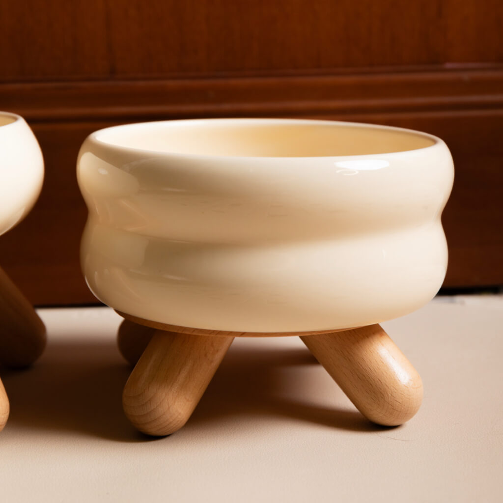 Cream White Gulu Ceramic Pet Bowl with ripple design and wooden legs.