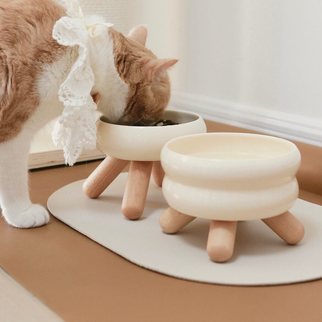 Gulu Ceramic Pet Bowl - Cream White in a bright, modern home interior with wooden legs.