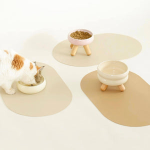 Cat eating from ceramic bowl placed on beige Meoof Gulu pet placemat – minimalist feeding setup for cats and dogs.