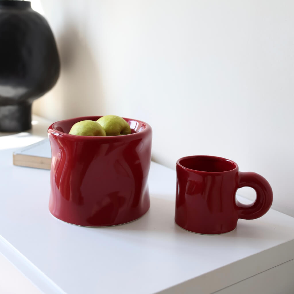 Pinch Ceramic Mug & Elevated Pet Bowl Set – Bordeaux Red – Elegant Bordeaux red ceramic mug and pet bowl set, placed on a minimalist white shelf with fresh green apples inside the bowl.