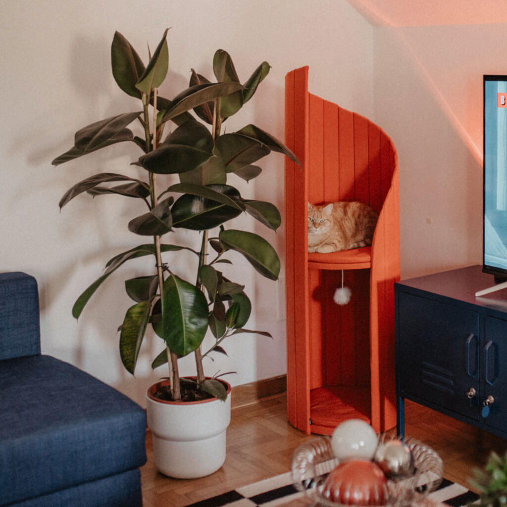 Modern Time Travel Tower Cat Tree in Red, perfectly complementing a contemporary living room with vibrant decor and lush plants.