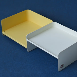 White and yellow metal pet bowl stands side by side on blue background – minimalist, dual-height design for cats and dogs.