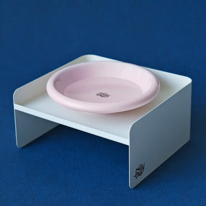 White minimalist metal pet bowl stand with soft pink dish – ergonomic dual-height feeder for cats and small dogs.