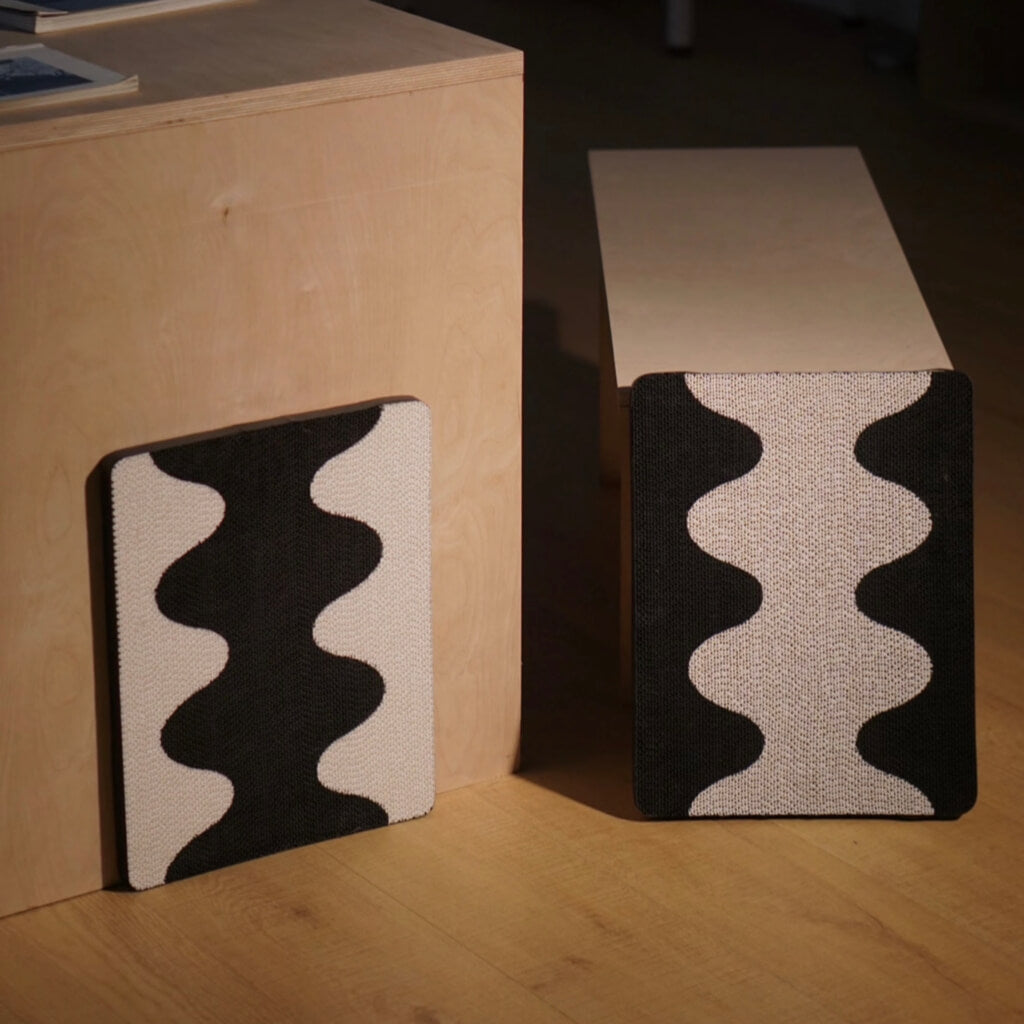 Two Coral Cat Scratching Pads with black-and-white wave design mounted on wooden furniture