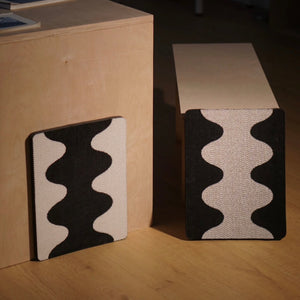 Two Coral Cat Scratching Pads with black-and-white wave design mounted on wooden furniture