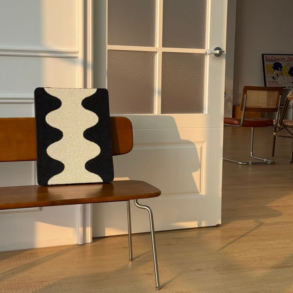 Coral Cat Scratching Pad with modern wave pattern resting on wooden bench in sunlit room