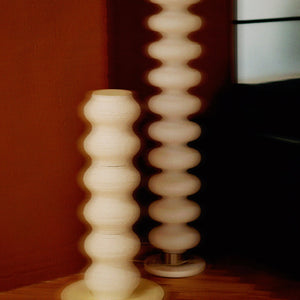 Two wavy minimalist white cat scratching posts side by side, enhancing a modern living space with their smooth, elegant design.