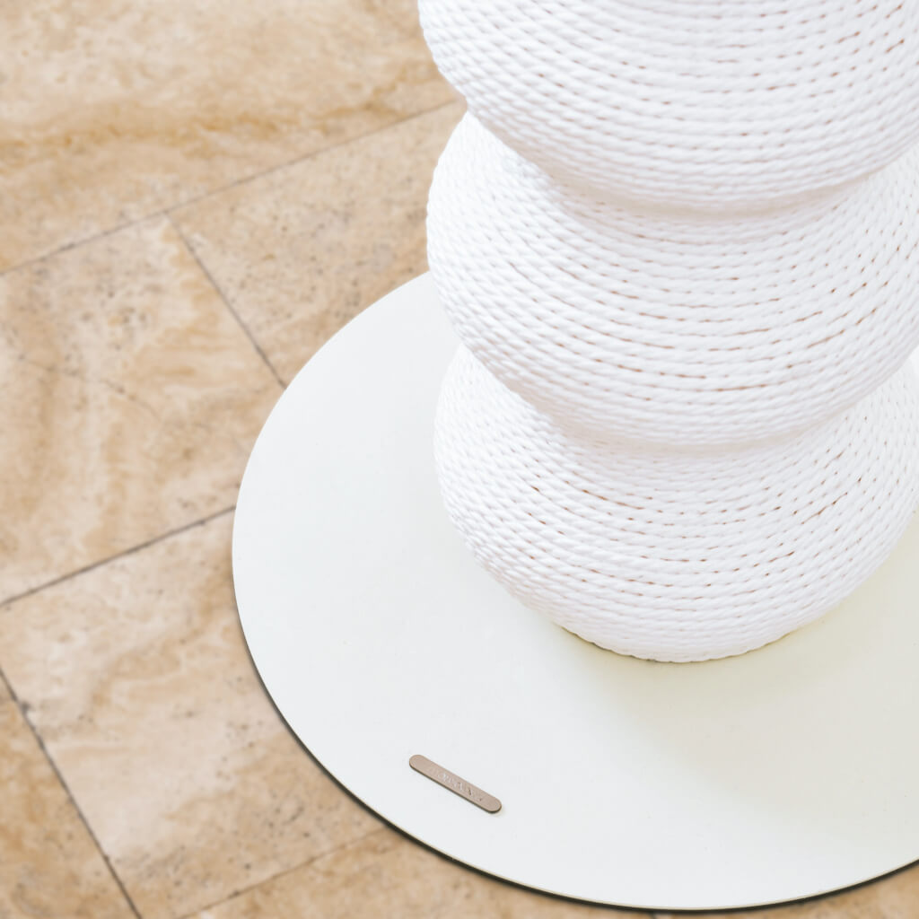 Close-up of the white base of the minimalist design wavy scratching post, showing its sturdy, powder-coated surface for stability and elegance.
