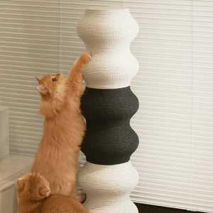 Ginger cat scratching a black and white Minimalist Wavy Scratching Post, a functional and space-saving cat scratcher that keeps claws healthy.
