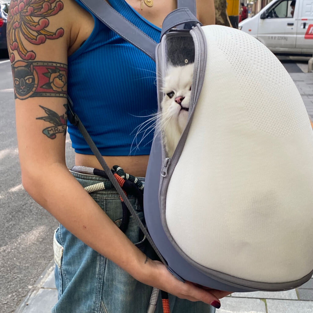Stylish woman carrying her cat inside the Extra-light Cat Travel Backpack, ideal for urban adventures.
