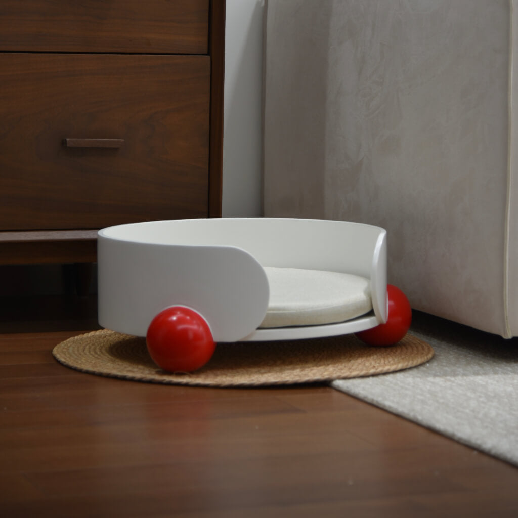 White and red HugMe Pine Wood Pet Lounger placed beside a bed – Sleek and modern cat furniture that integrates seamlessly into stylish home décor.