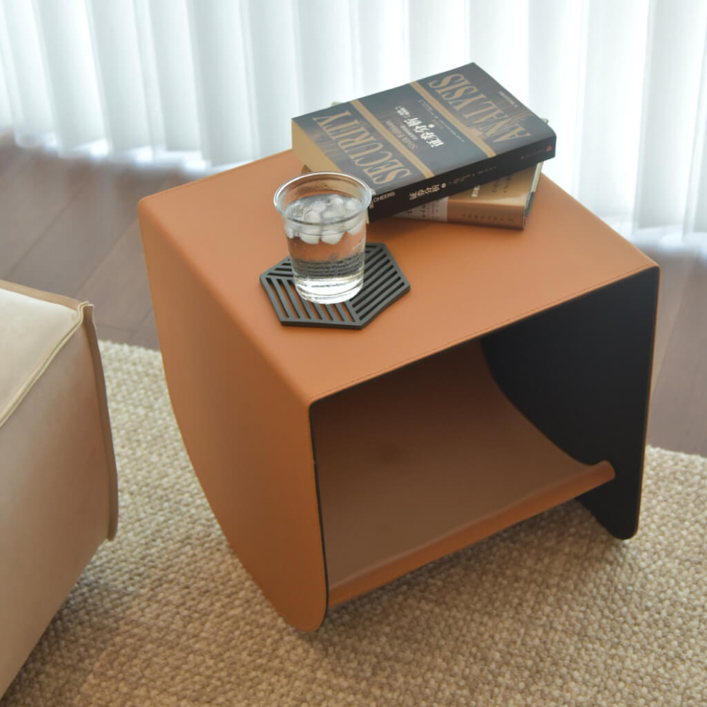 uxury saddle leather cat cave and side table, elegantly styled with books and drinks, showcasing its versatile design.
