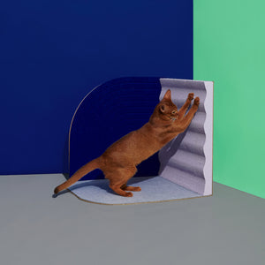Cat Stretching on Scratcher: Brown cat stretching and scratching on the Purrre 3-Dimensional Design Cat Scratcher in Velvet Blue, designed for feline playtime and rest.