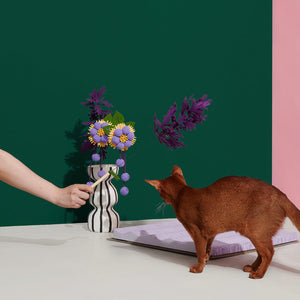 A decor piece featuring the cat teaser in a vase with additional toy elements.