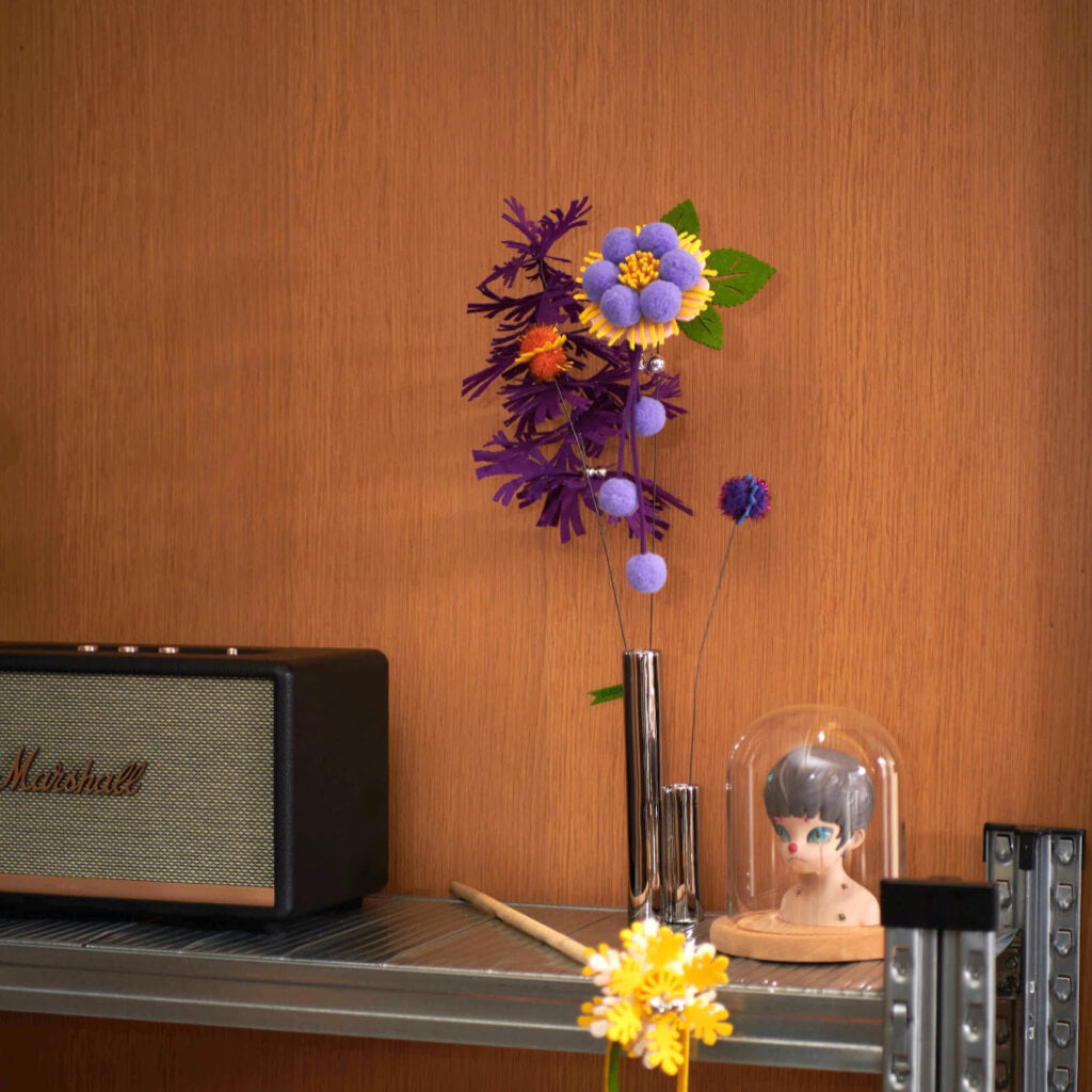 The Purrre Enchanting Cat Teaser displayed stylishly on a wooden shelf with artistic decor pieces.