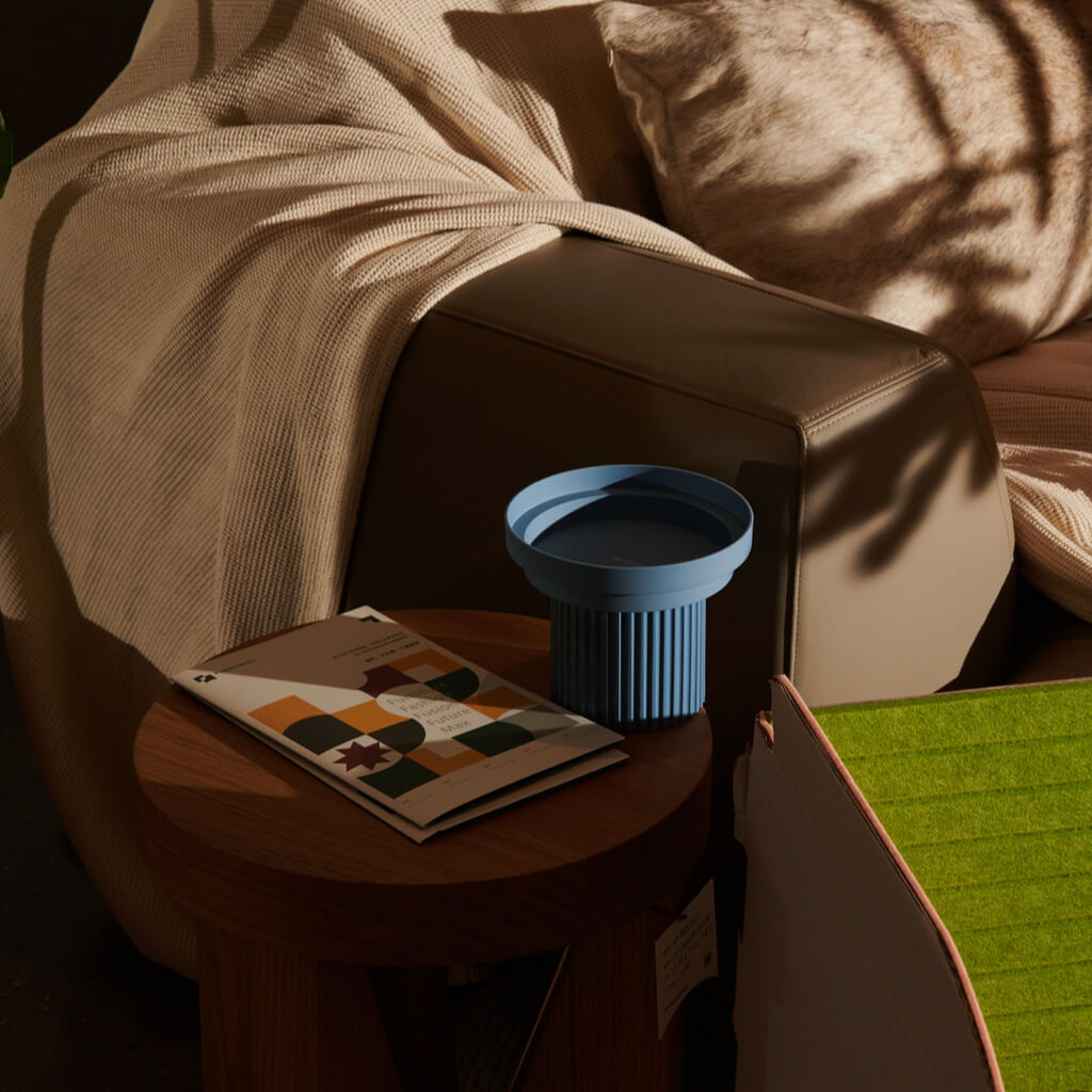 Purrre Teeth Party Pet Bowl - Airy Blue on a side table in cozy living room setting.