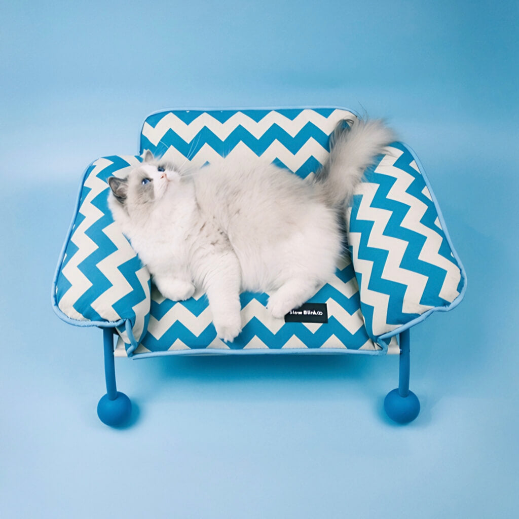 Blue and white chevron cat hammock & sofa bed with a fluffy Ragdoll cat lounging. This modern elevated pet lounger blends comfort, design, and functionality.