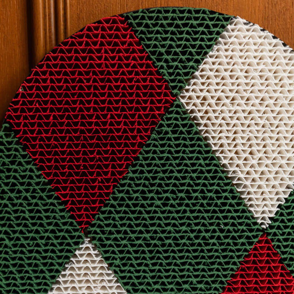 Close-up of green and red geometric patterns on the Checker cat scratcher.