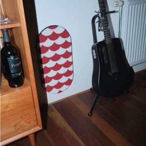 Red and white Koi Fish pattern cat scratcher mounted on a wall beside a guitar in a stylish interior setting.