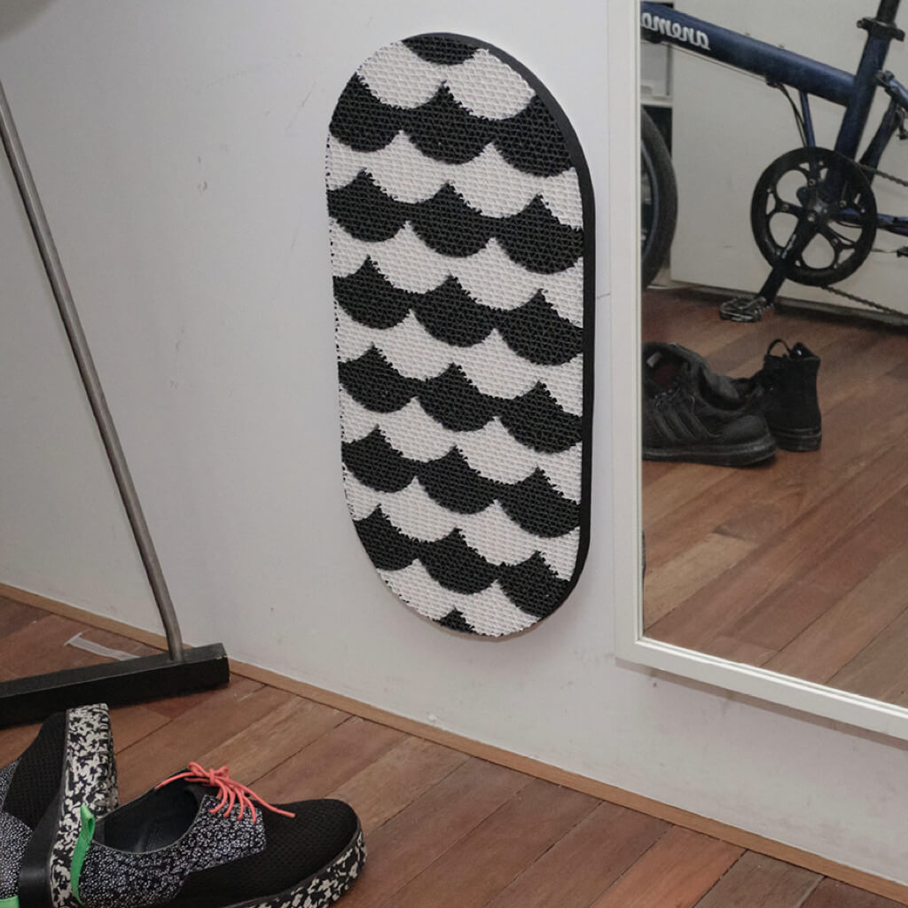 Black and white Koi Fish pattern cat scratcher displayed in a modern home setting with minimalist decor.