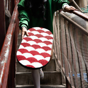 Woman carrying a red and white Koi Fish pattern cat scratcher up a staircase, highlighting its portability.