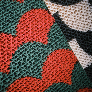 Close-up of the detailed red, green, and black Koi Fish pattern texture on the eco-friendly corrugated cardboard cat scratcher.