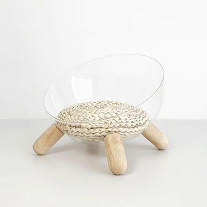 Transparent cat bed with handwoven corn husk mat and wooden legs