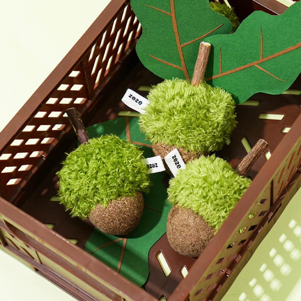 Box of ZEZE plush catnip acorn toys with natural stick detail and playful green leaf decor.