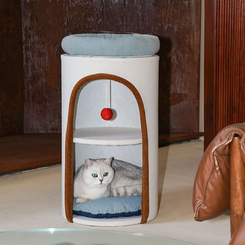 Cat peeking from inside denim-inspired cylindrical cat hideout with multi-level design.