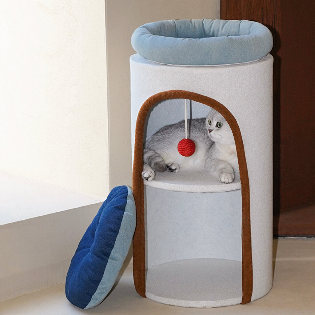 Multi-level cat condo with blue denim cushion and minimalist modern design, next to wooden bench.