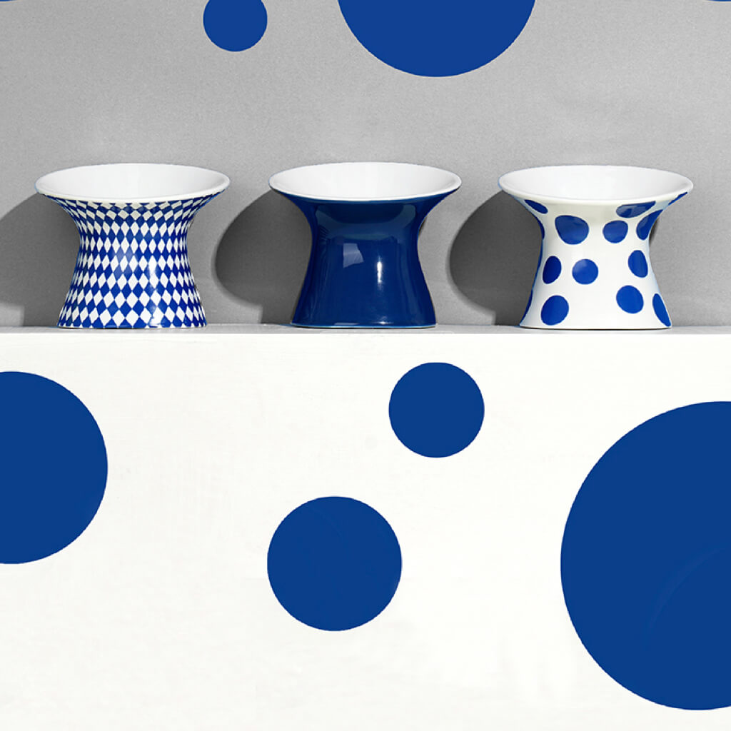 Blue Polka Dot Elevated Ceramic Pet Bowl displayed with modern home decor elements.