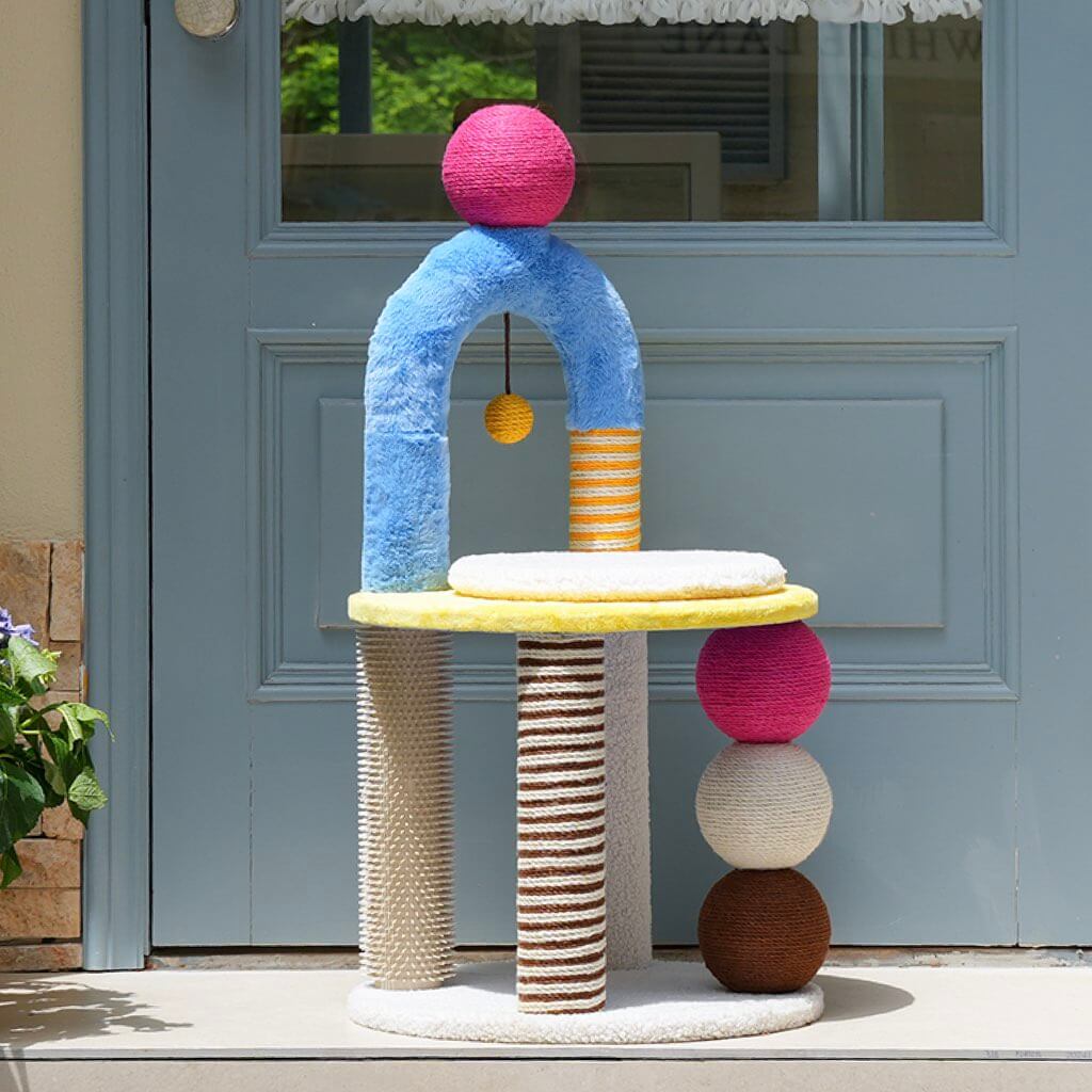 PlayPop Geometric Cat Tree placed by a door, featuring hanging play ball and scratch posts