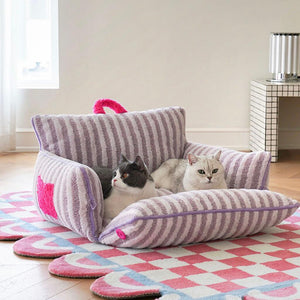 Two cats lounging in purple striped plush cat bed with removable cushion.