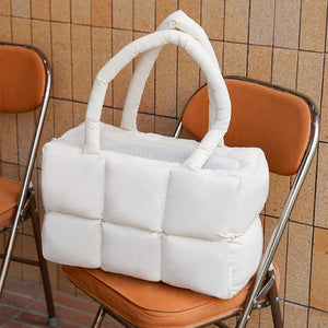 Breathable and soft quilted puffer pet carrier placed on a chair, showcasing its elegant and modern design.