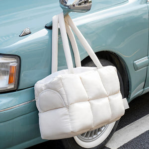 Travel-friendly quilted puffer pet carrier hanging on a vintage car, adding a chic touch to pet transportation.