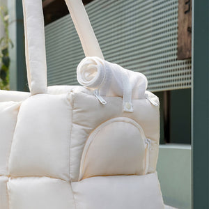 Close-up of the ZEZE Quilted Puffer Pet Carrier’s side pocket, featuring a rolled-up breathable mesh cover secured with a snap button.