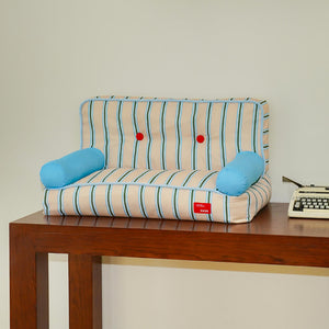 Retro-style striped pet sofa with blue bolsters on a wooden table – ZEZE cat and dog bed.